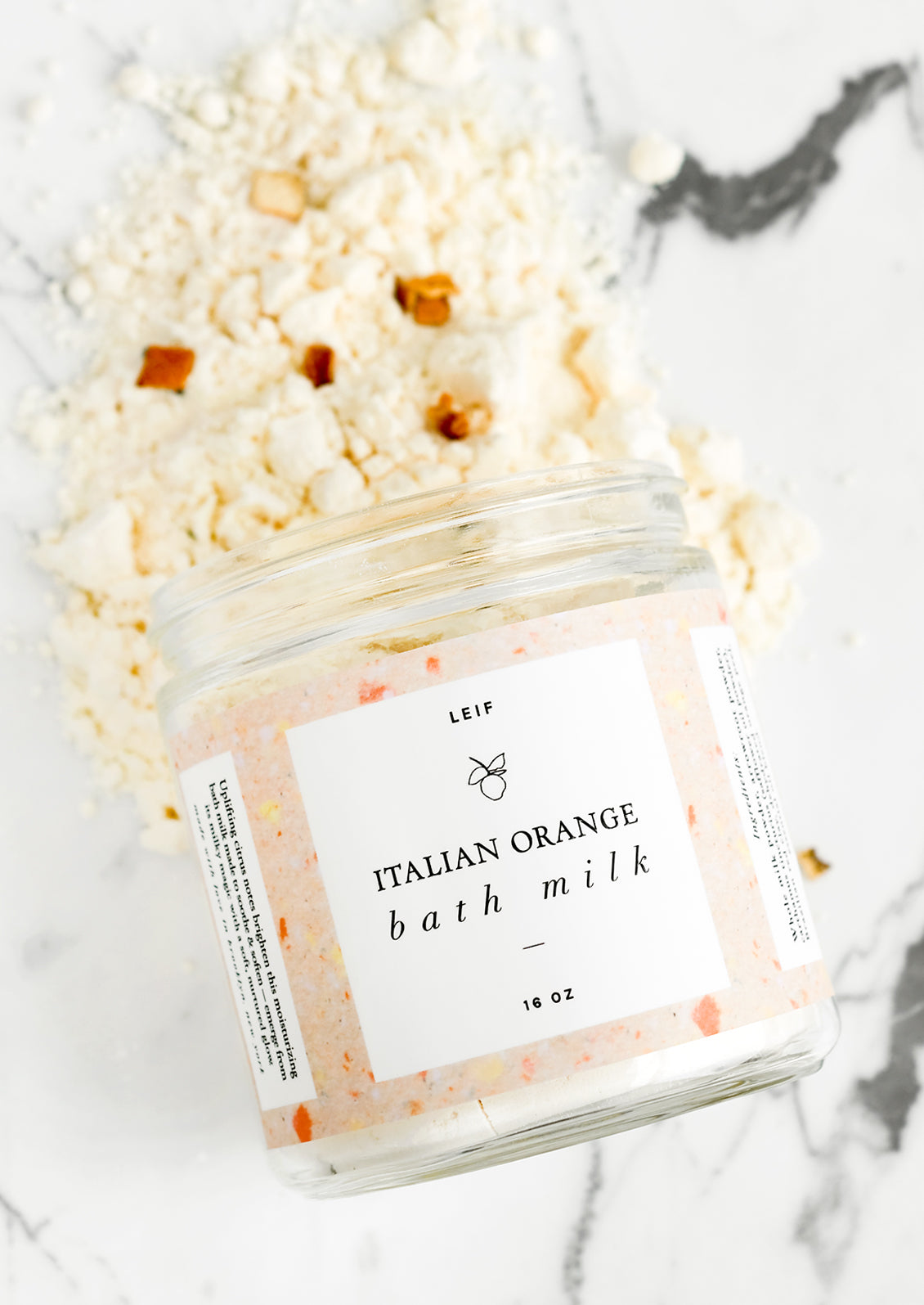 An orange scented milk bath in glass jar.