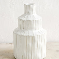 2: A textured white vase in an asymmetrical shape.