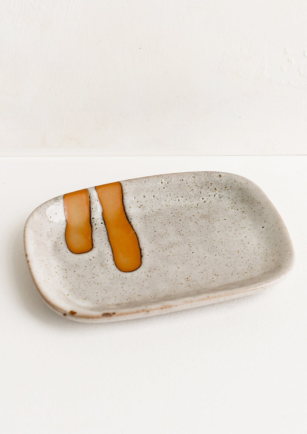 2: A rectangular ceramic dish with stroke detail.