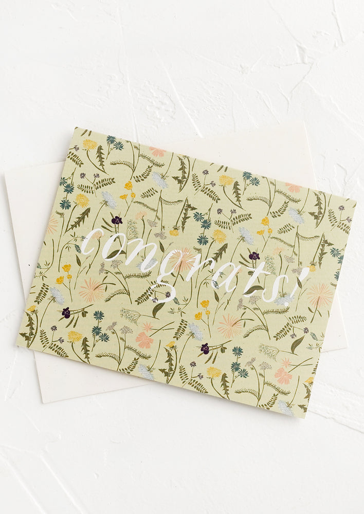 A greeting card with wildflower print reading "Congrats!".