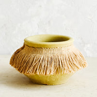 Small: Short, ochre colored clay vase with fringed jute trim around opening