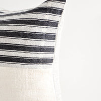 2: Square throw pillow with white and black striped top half and plain mudcloth bottom half