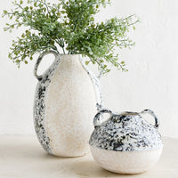 1: Distressed ceramic vases in ivory and grey, sitting on a table.