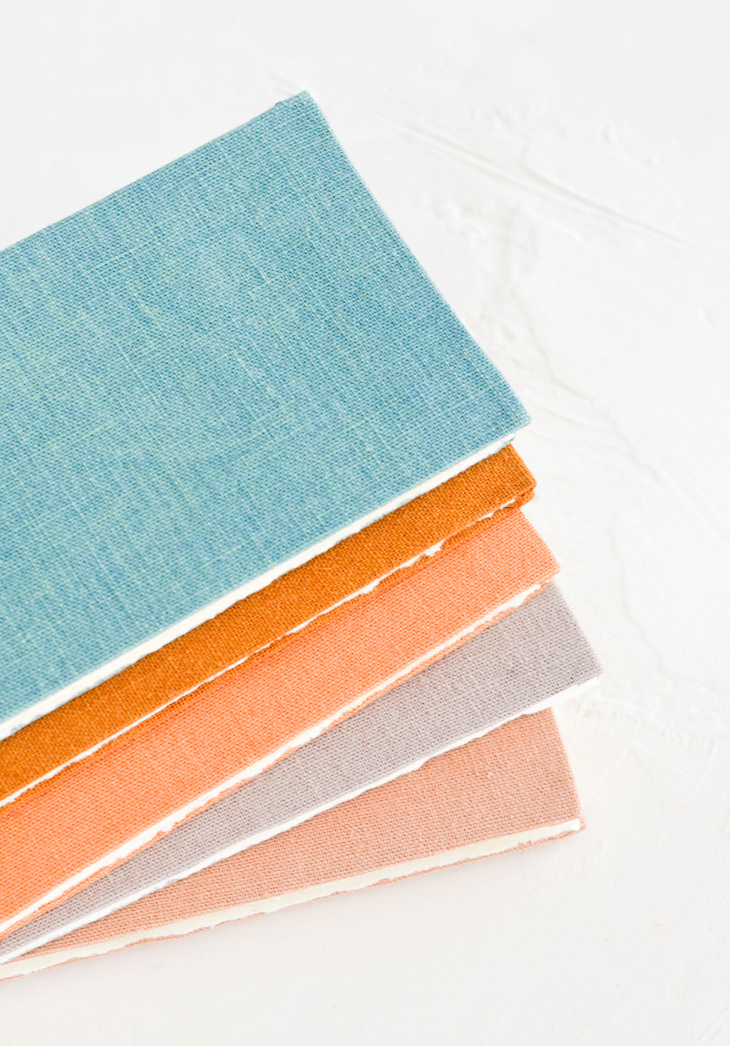 4: Five cloth-covered notebooks in naturally dyed hues.