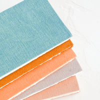 4: Five cloth-covered notebooks in naturally dyed hues.