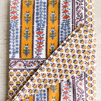 2: A stripe floral print tablecloth in marigold, purple and blue.