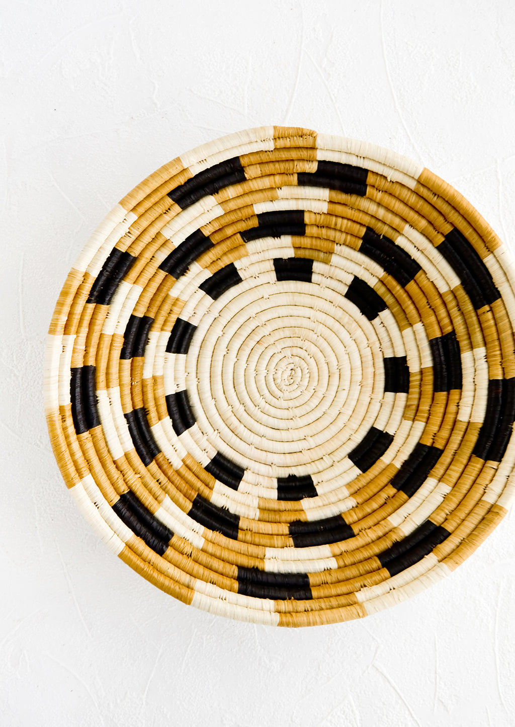 1: Round woven raffia bowl with checkered pattern in natural, tan and black