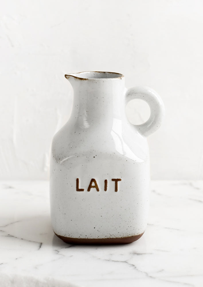 A small white and brown ceramic pitcher with "Lait" text.