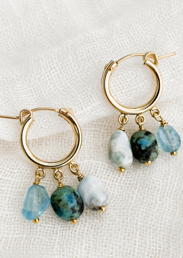 1: A pair of gold hoop earrings with triple turquoise dangling stones.