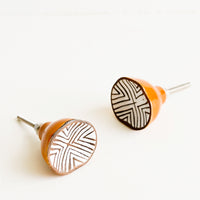1: Round ceramic cabinet knobs with brown base and white chevron patterned front.