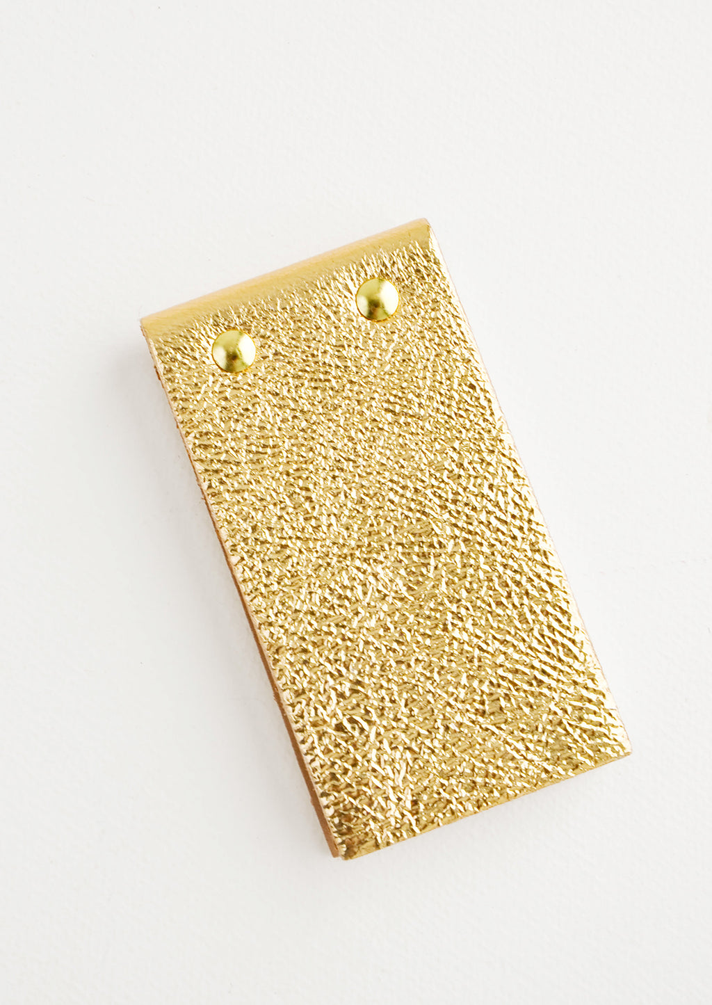 Gold Pebble: Small gold leather notepad with brass grommets.