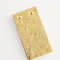 Gold Pebble: Small gold leather notepad with brass grommets.
