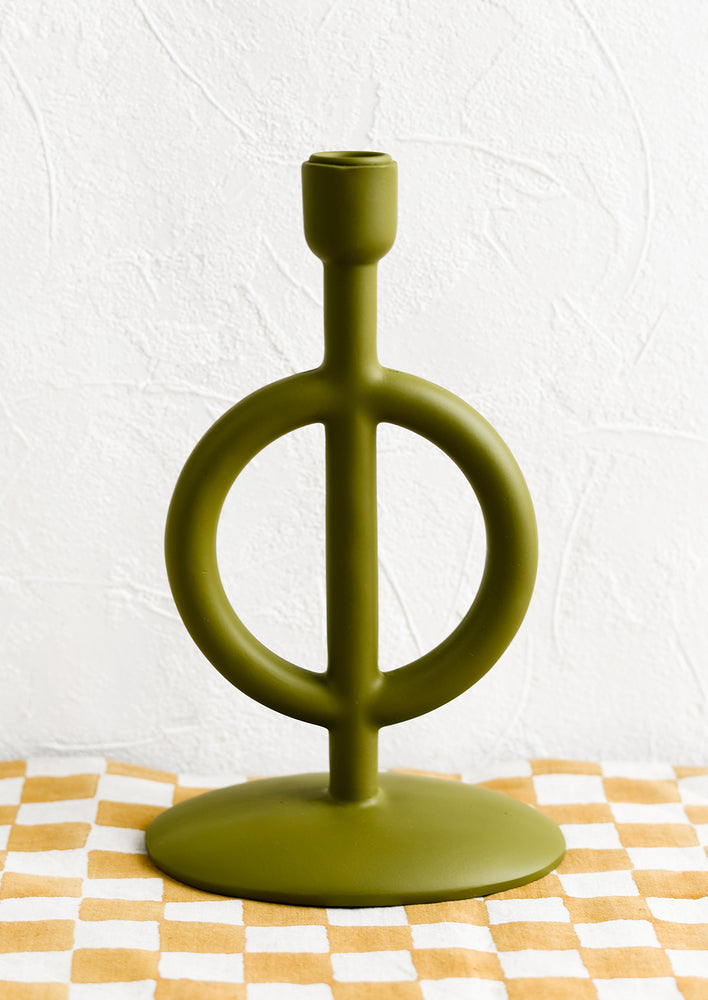 A sculptural taper candle holder in matte olive green resin.