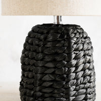 2: A table lamp with black woven base and linen shade.