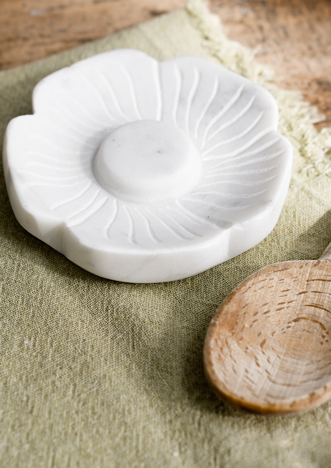 A white marble spoon rest in flower shape.