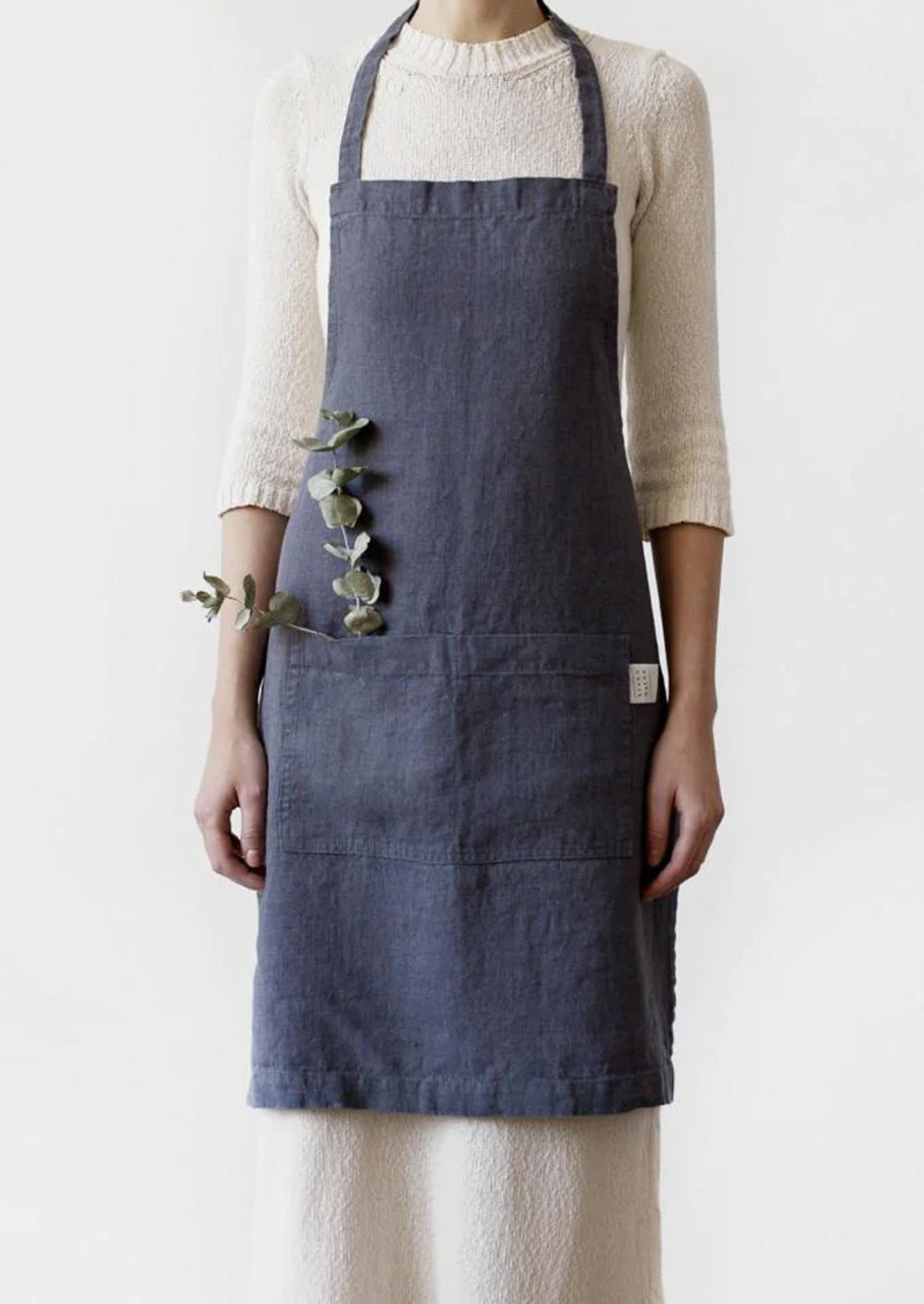 Cinder: A women wearing a linen apron in dark grey color.