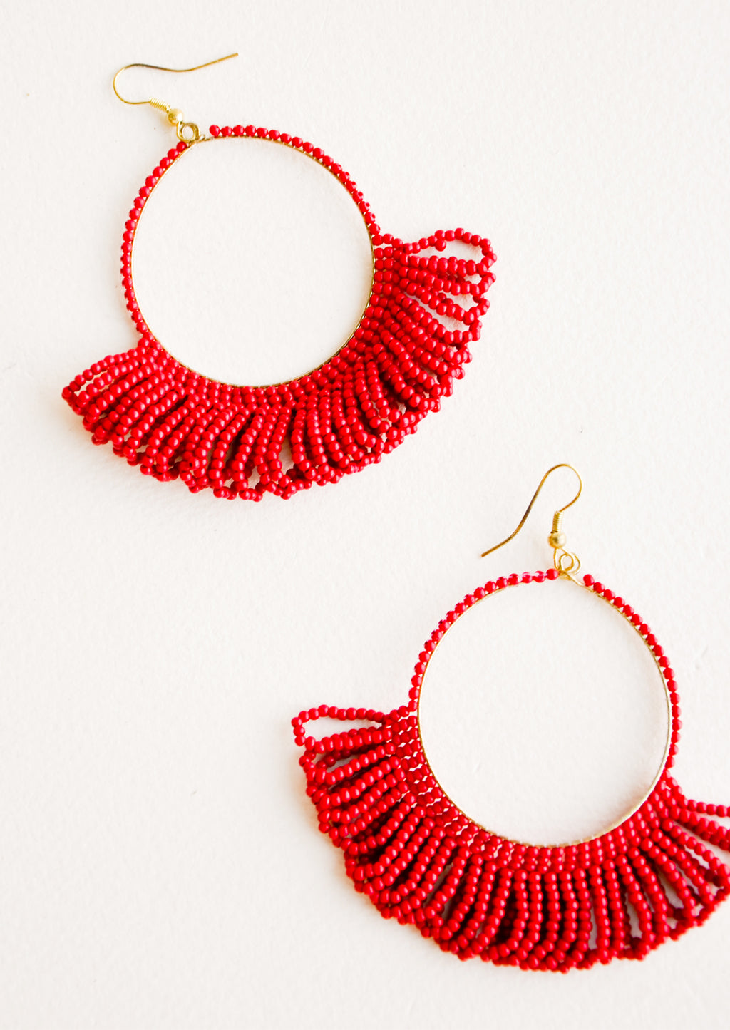 Cherry: Dangling hoop earrings featuring bright red beads and accented with hanging beaded, looped fringe.