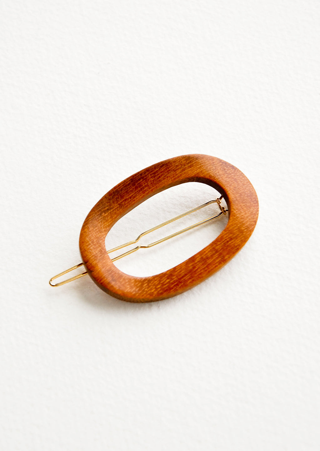 Brown: Oval shaped hair clip made out of brown wood with gold clasp