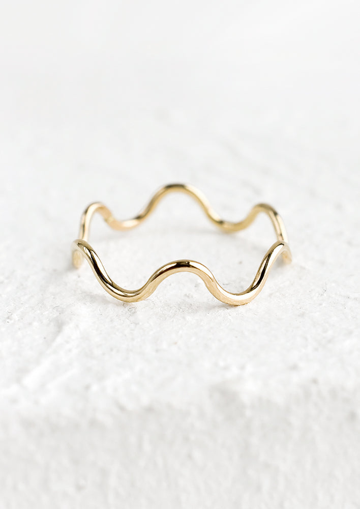 A thin gold ring in wavy shape.