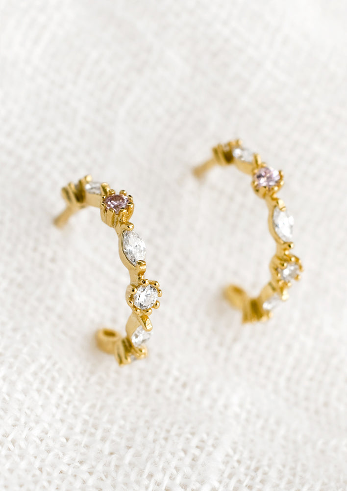 1: A pair of gold hoop stud earrings with clear and pink crystal detailing.