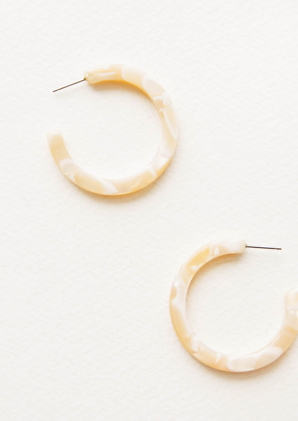 Ivory Shell: Three quarter hoop earrings in marbled ivory and beige acetate.