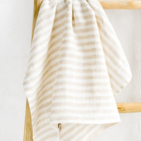Natural Stripe: A tan striped linen tea towel draped on a wooden ladder.