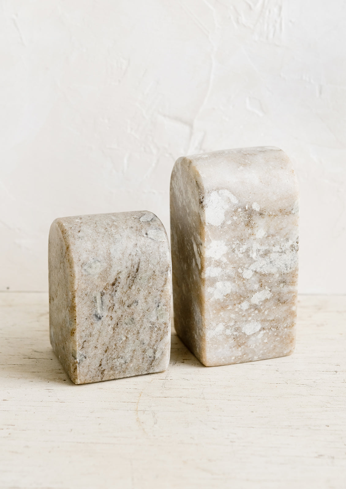 A pair of marble arch-shaped bookends in short and tall heights.