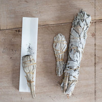 2: A long solid marble incense burner tray, shown with sage smudge bundles.
