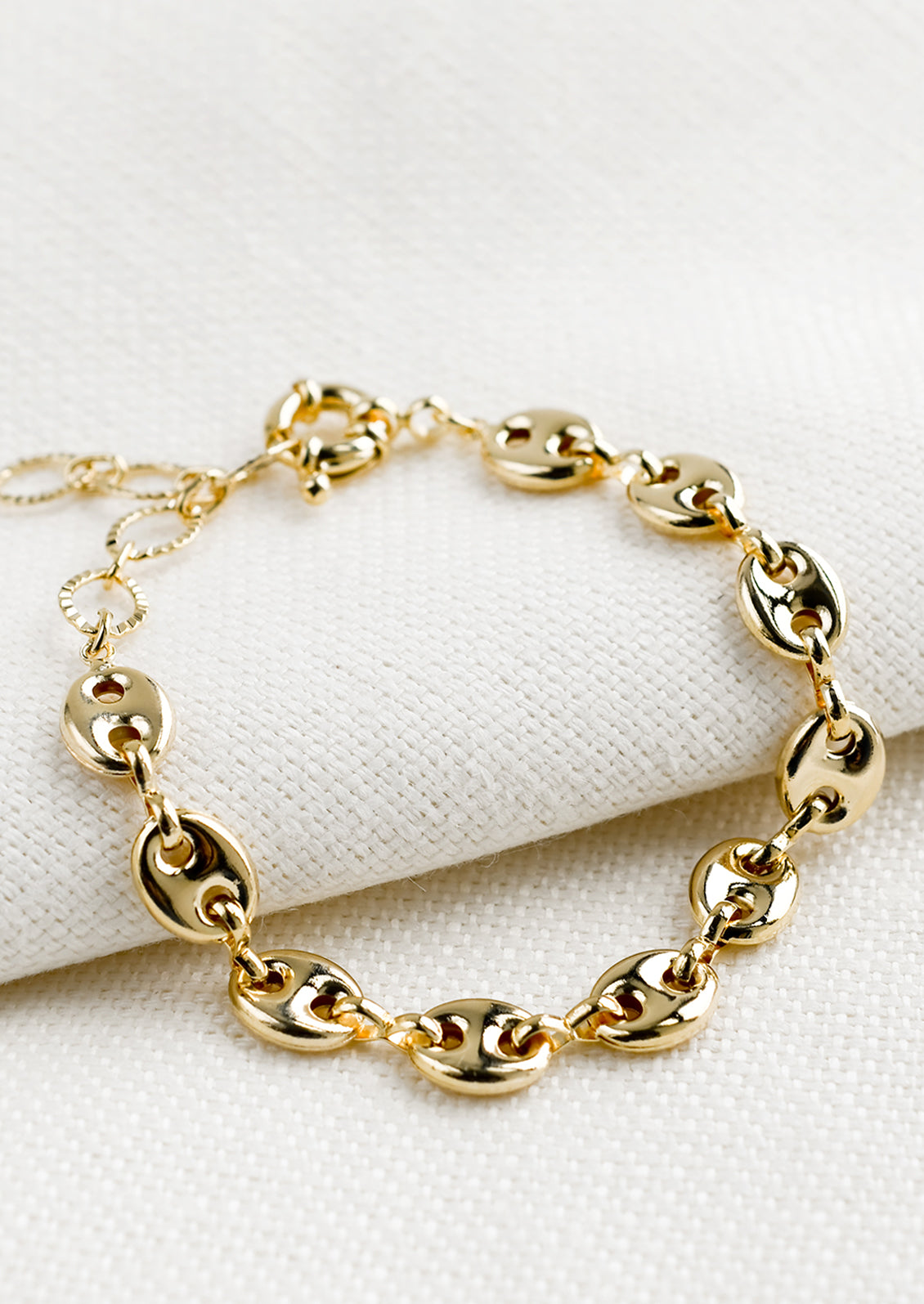 A gold bracelet with puffy mariner chain.