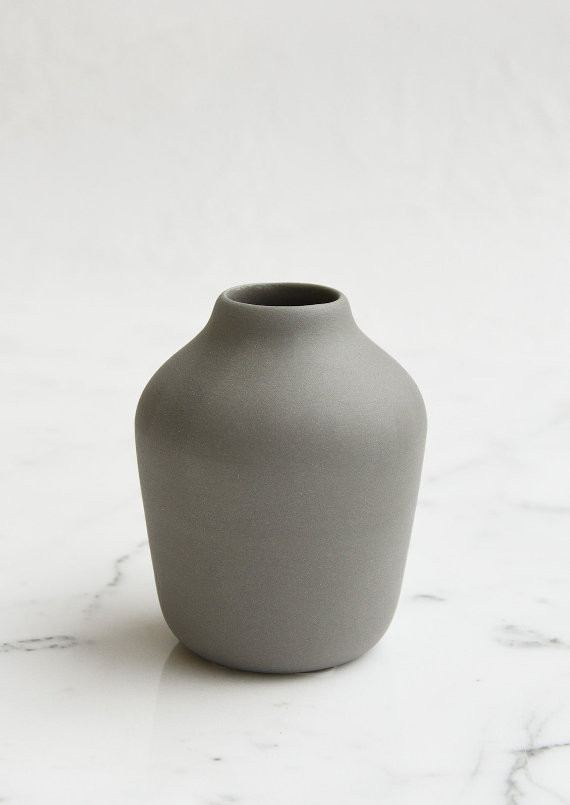 A charcoal colored porcelain bud vase.