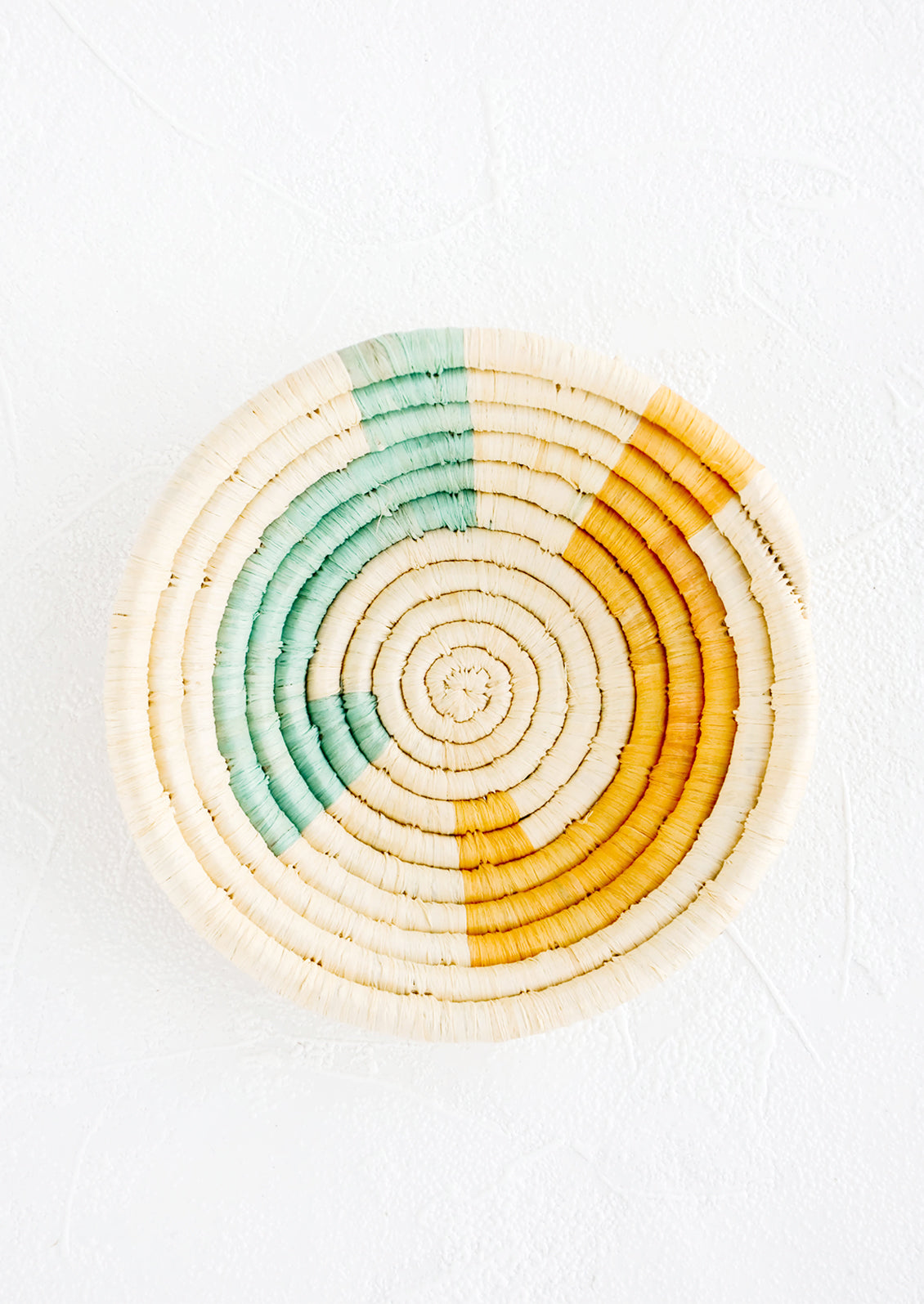 Small raffia bowl in geometric pattern in natural, aqua and yellow