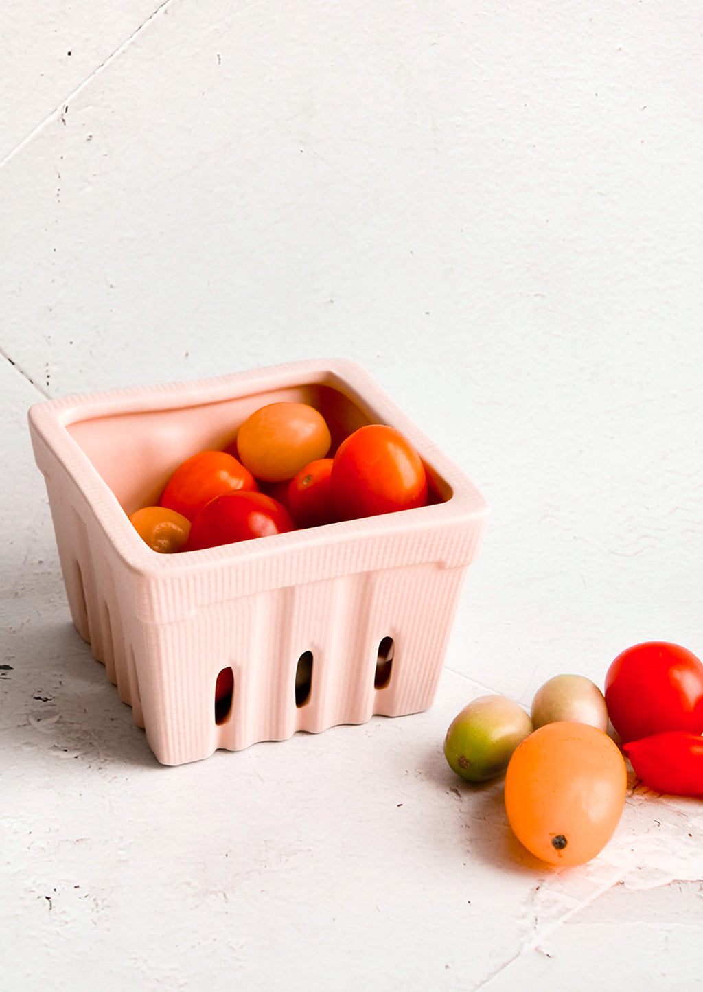 Blush: Ceramic basket in the style of disposable berry basket, displayed with cherry tomatoes
