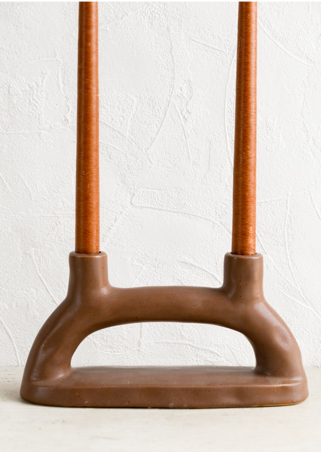 2: A brown ceramic candleholder for two candles.