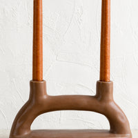 2: A brown ceramic candleholder for two candles.