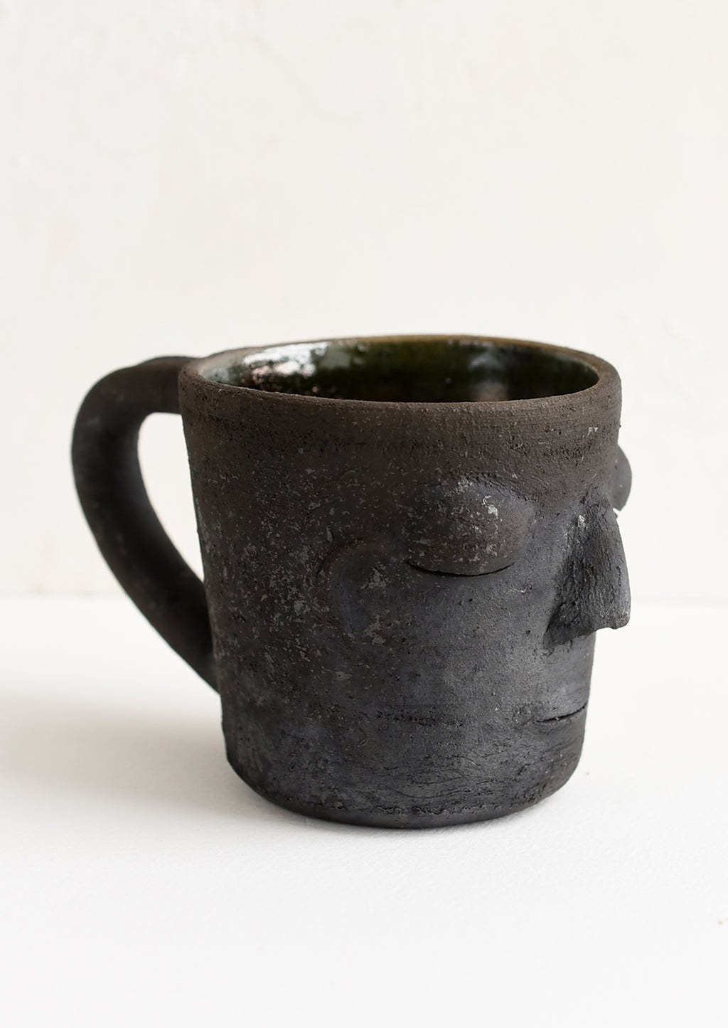 Black: A clay mug in matte black color in face shape.