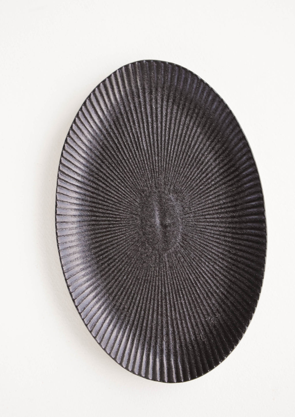 3: Oval-shaped, black ceramic tray with radiating lines pattern