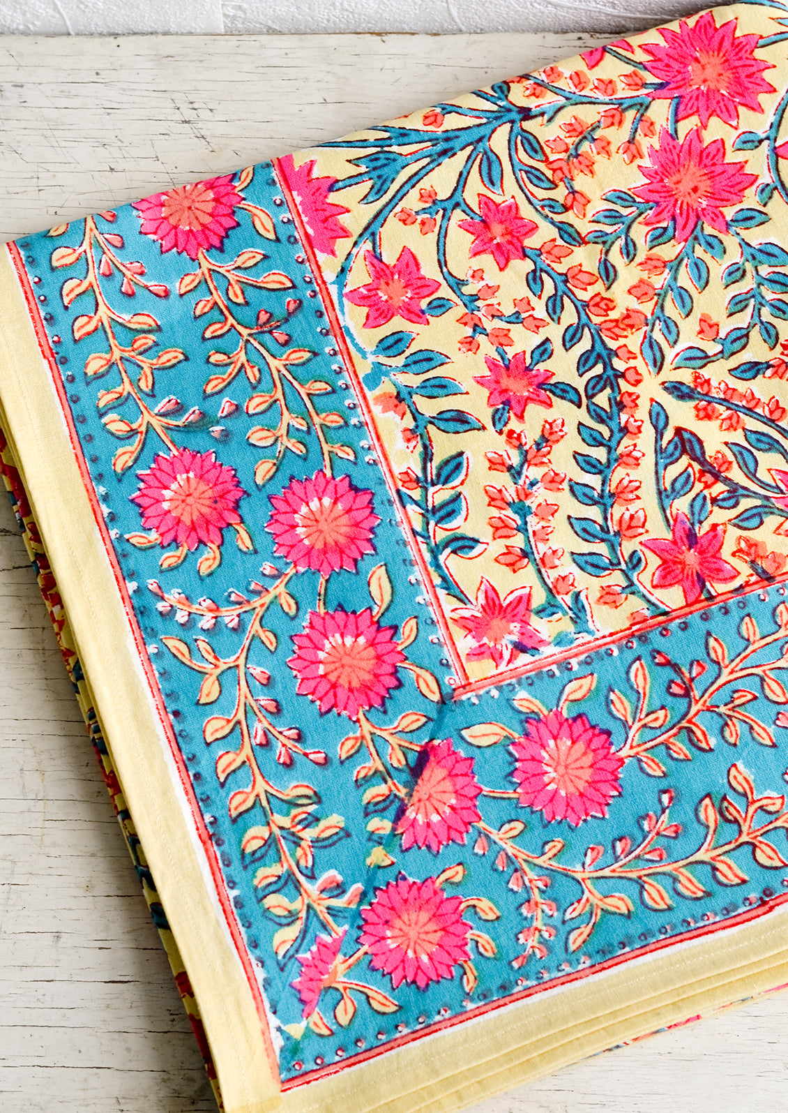 A vibrantly colored block printed tablecloth with floral print.