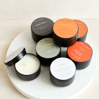 1: Small soy candles in assorted scents, packaged in black metal tins.