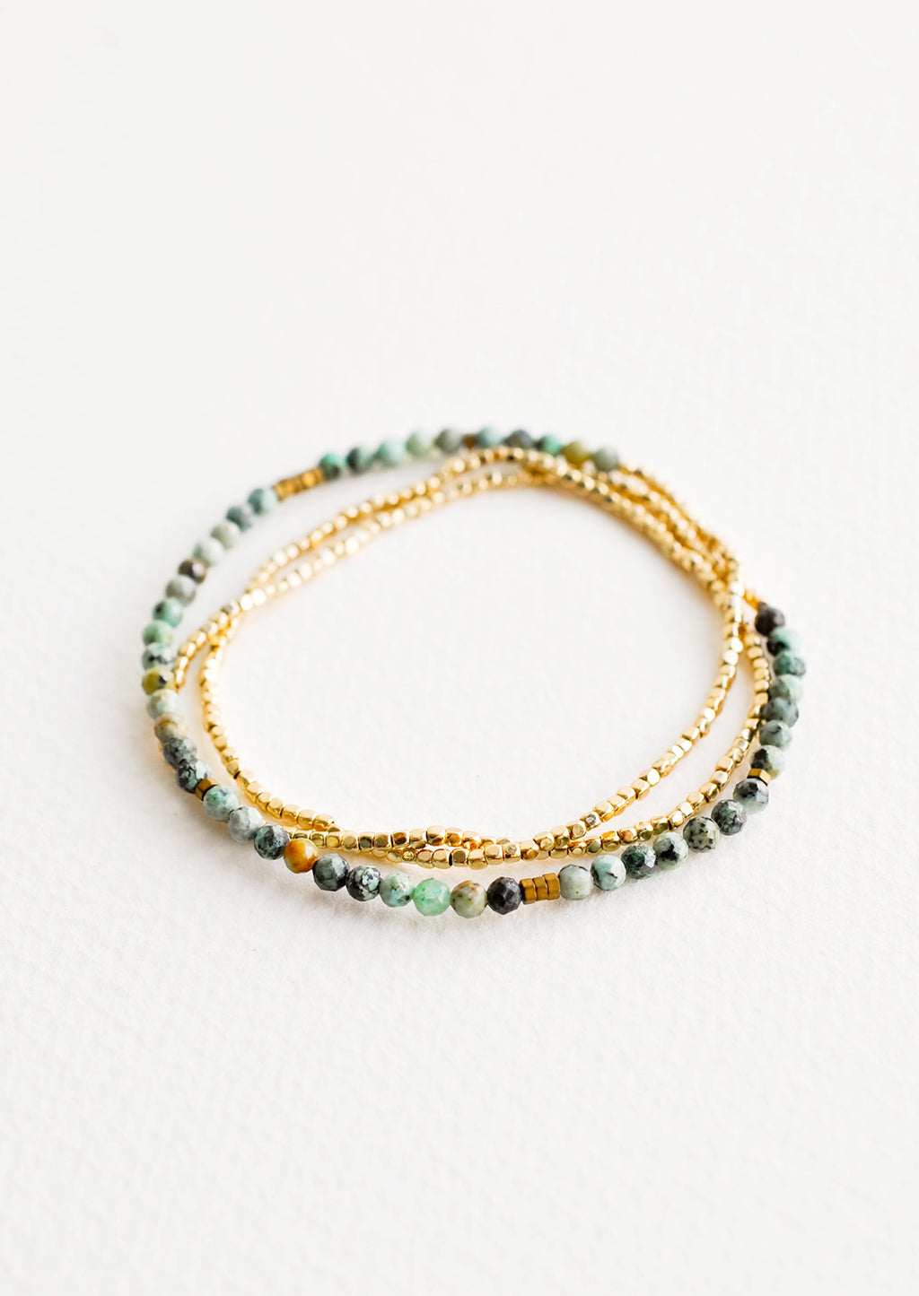 African Turquoise: A single strand bracelet of gold and multi-colored turquoise beads wrapped upon itself in three layers. 