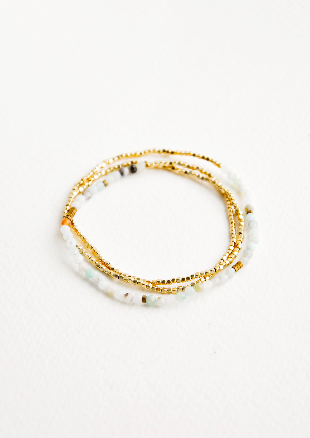 Amazonite: A single strand bracelet of gold and play green stone beads wrapped upon itself in three layers. 