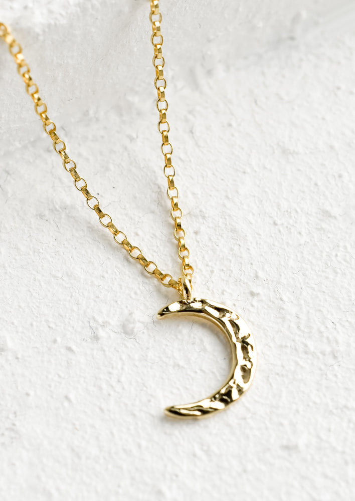 1: A gold necklace with hammered crescent moon charm.