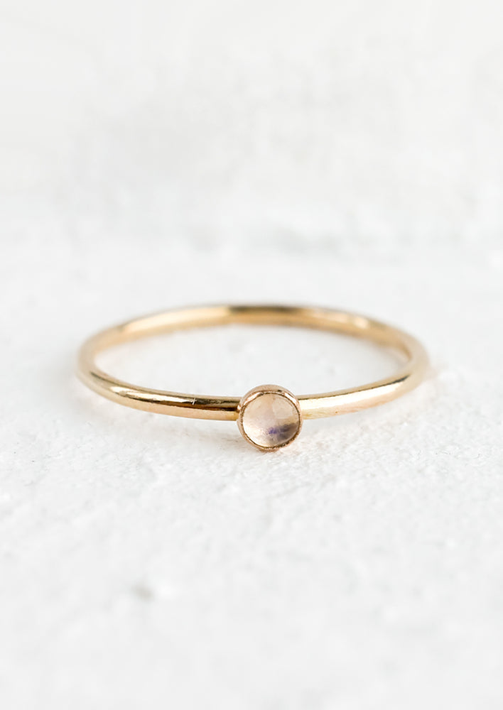 1: A thin gold ring with round bezeled moonstone.