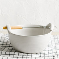 2: A white ceramic bowl with top handles that fit included whisk.