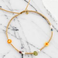 Gold / Peridot: A gold seed bead bracelet with mixed flower and gemstone beads.