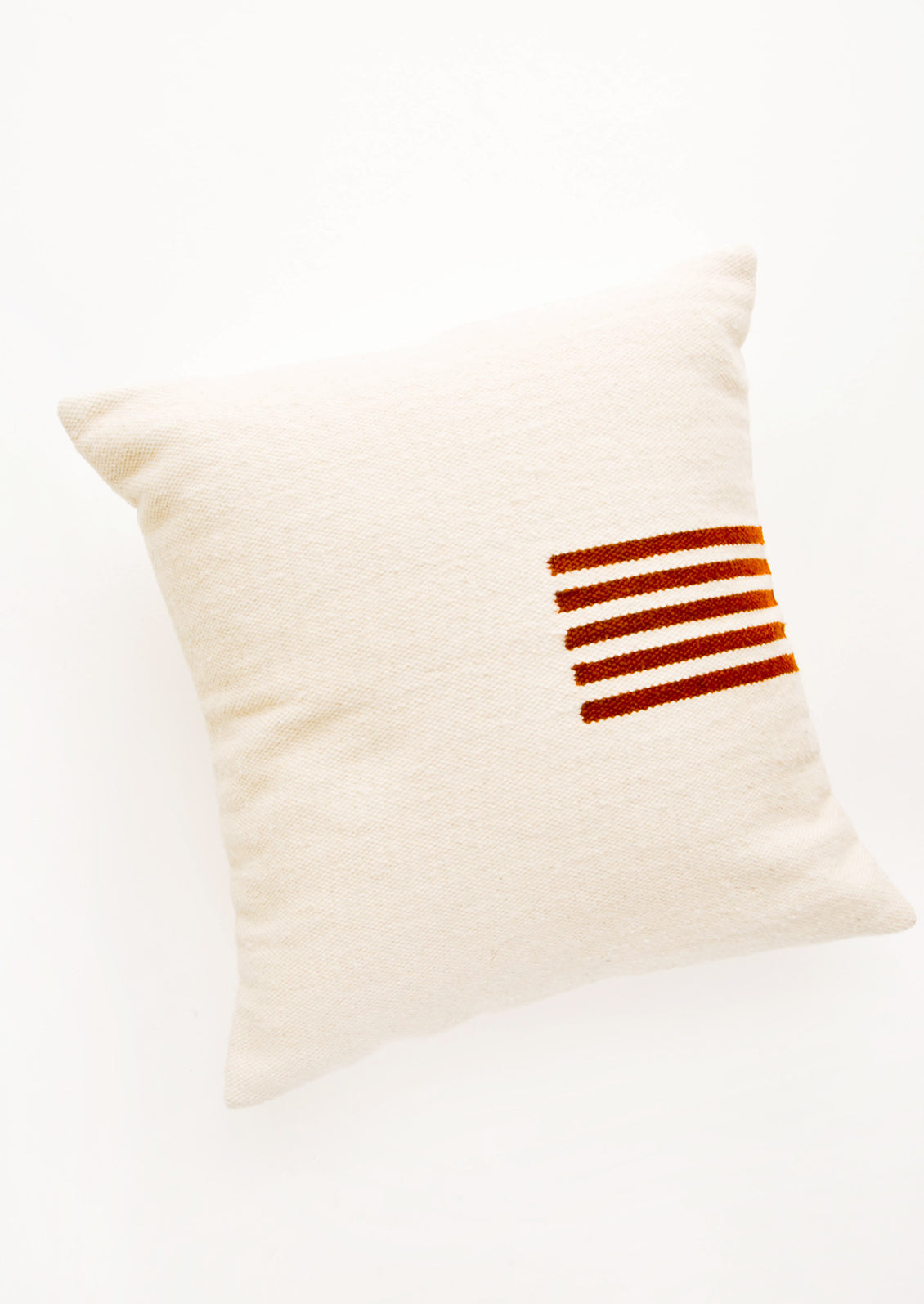 Ivory colored, square wool throw pillow with contrasting small stripe detail at side.