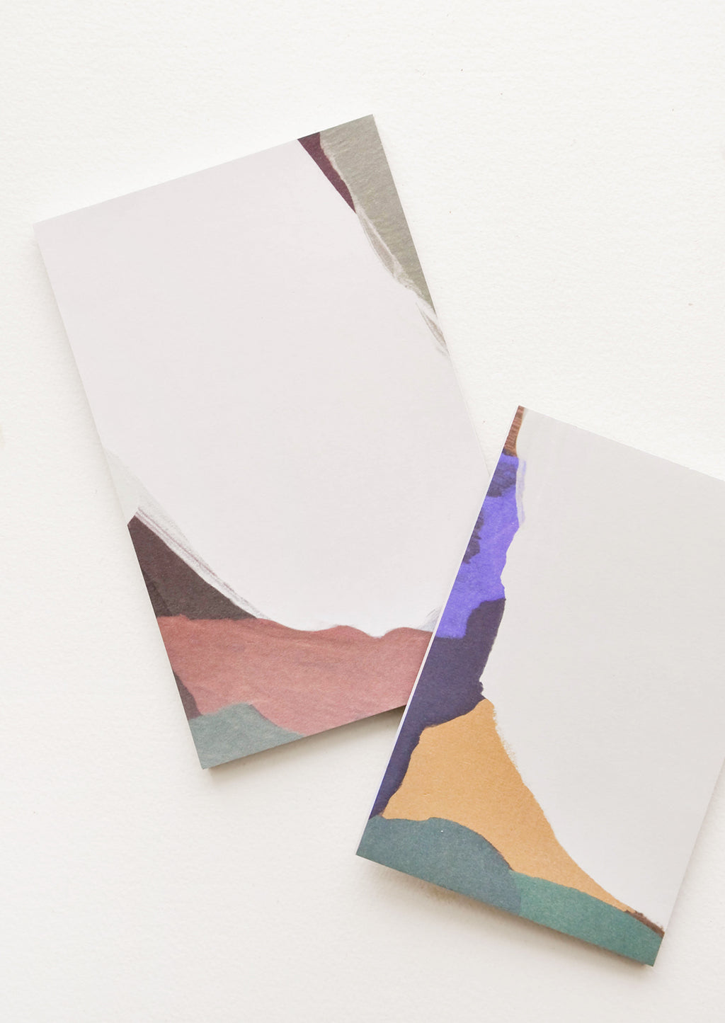 4: Two notepads, decorated with colorful abstract shapes.