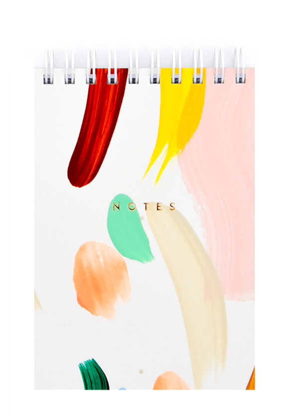 Small spiral bound white notepad with cover decorated in colorful, hand-painted paint strokes