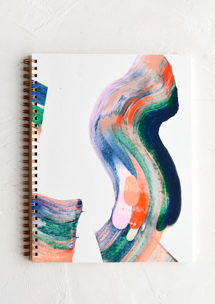 A spiral bound book with handpainted cover showing multicolor swirl pattern.