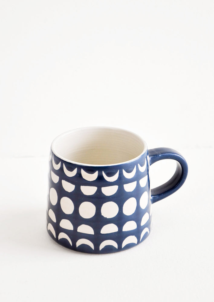 1: Ceramic mug in navy blue glaze with allover white moon phases print