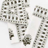2: A pair of white napkins with block printed motif in moss green.